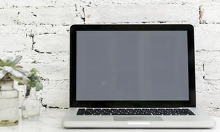 laptop on white brick wall background