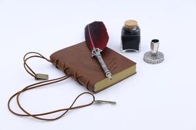 fountain pen with Feather on closed book and inkwell