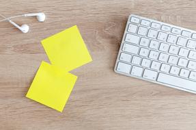 yellow stickers, headphones and keyboard on the table