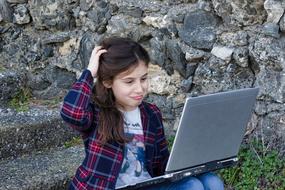 girl work on laptop sitting on stone steps