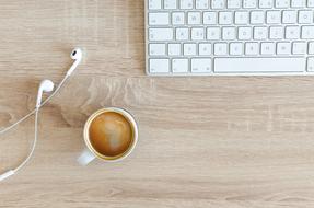 white keyboard white headphones and a white Cup of tea