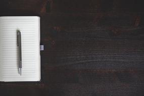 white Notebook and Pen black table