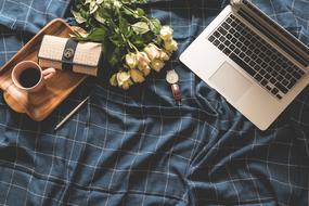 laptop, coffee an flowers on blue tissue