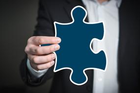 blue puzzle in the hands of a business man