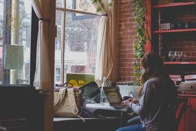 young woman with laptop in cafe