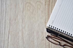 Notebook, Pen and glasses close up on the table