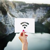 card with wifi Signal symbol in female hand at scenic Landscape