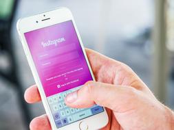 Person, logging in to Instagram on the white Iphone