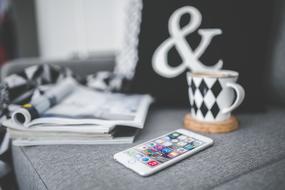 smartphone, coffee and magazines on sofa