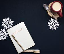 notebook with pen and coffee with milk in a cup on the table