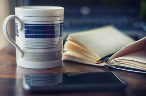 closeup view of striped mug and notebook