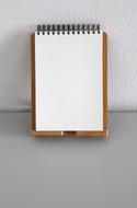 Blank notepad at wall