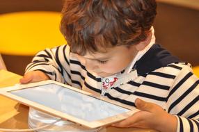 child with tablet close-up on blurred background