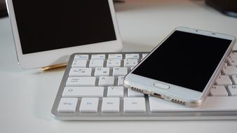 white smartphone, tablet and keyboard