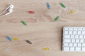 earphones, keyboard and colorful Paper Clips desktop