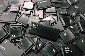 Many, shiny, black computer keys, with the white signs