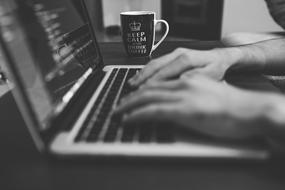 black and white, hands on laptop keyboard