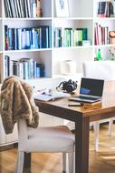 home office on the background of shelvings with books