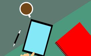 drawn tablet, red notebook and a cup of coffee on the table
