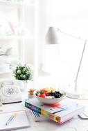 Fruits in bowl on stack of books