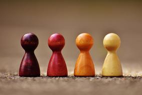 four wooden pins in different colors in row