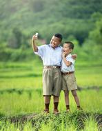 children take a selfie on a green meadow