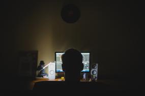 photo of the head of a young man on the background of a computer monitor