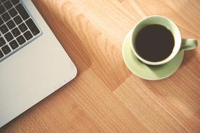 photo of laptop part and cup of coffee
