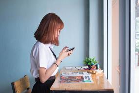 young Girl with Phone at desk