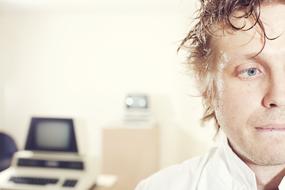 Portrait of programmer, with the half face, in light, in the laboratory