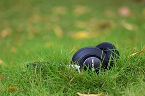 closeup picture of Black Head Phones on green Grass