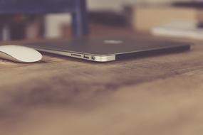 Macbook Air and white mouse on the beautiful, wooden desk