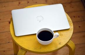 laptop and cup of coffee on a yellow coffee table