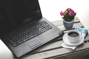 black laptop and Coffee in white cup