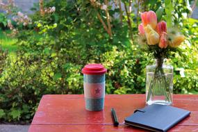 coffee mug, notebook and vase with tulips