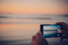 Person, taking photo of the beautiful sea, at colorful sunset, with Sony smartphone