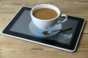 Cup with coffee on Tablet