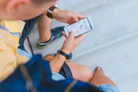 young boy sits with Smartphone