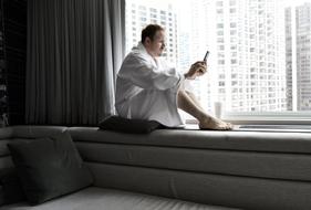 photo of a man in a white coat sitting on a windowsill