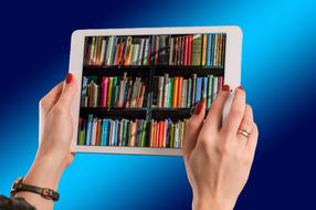 tablet in female hands with red manicure