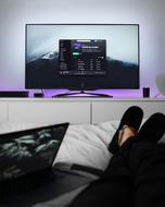 person laying on bed in front of tv