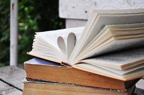 stack of books and heart-shaped pages