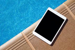 the tablet is lying by the pool