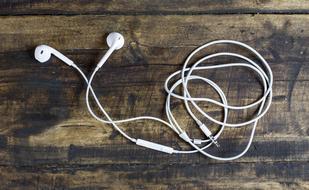 white wired headphones on a wooden table