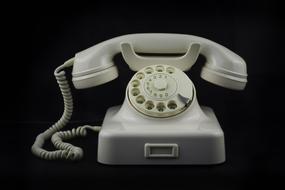 white retro phone on a black background