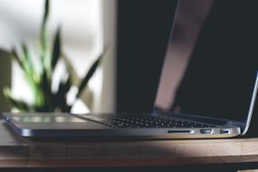 black laptop on wood table