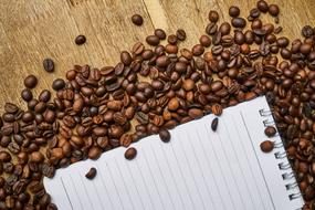 notebook and coffee beans on a wooden table