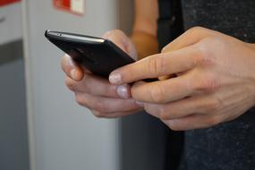 black smartphone in hands close up