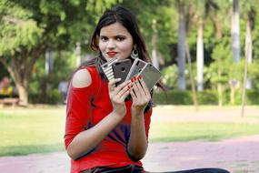 girl with mobile phones in her hands in the park