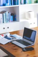 gadgets on Desk at bookshelves at Working Place